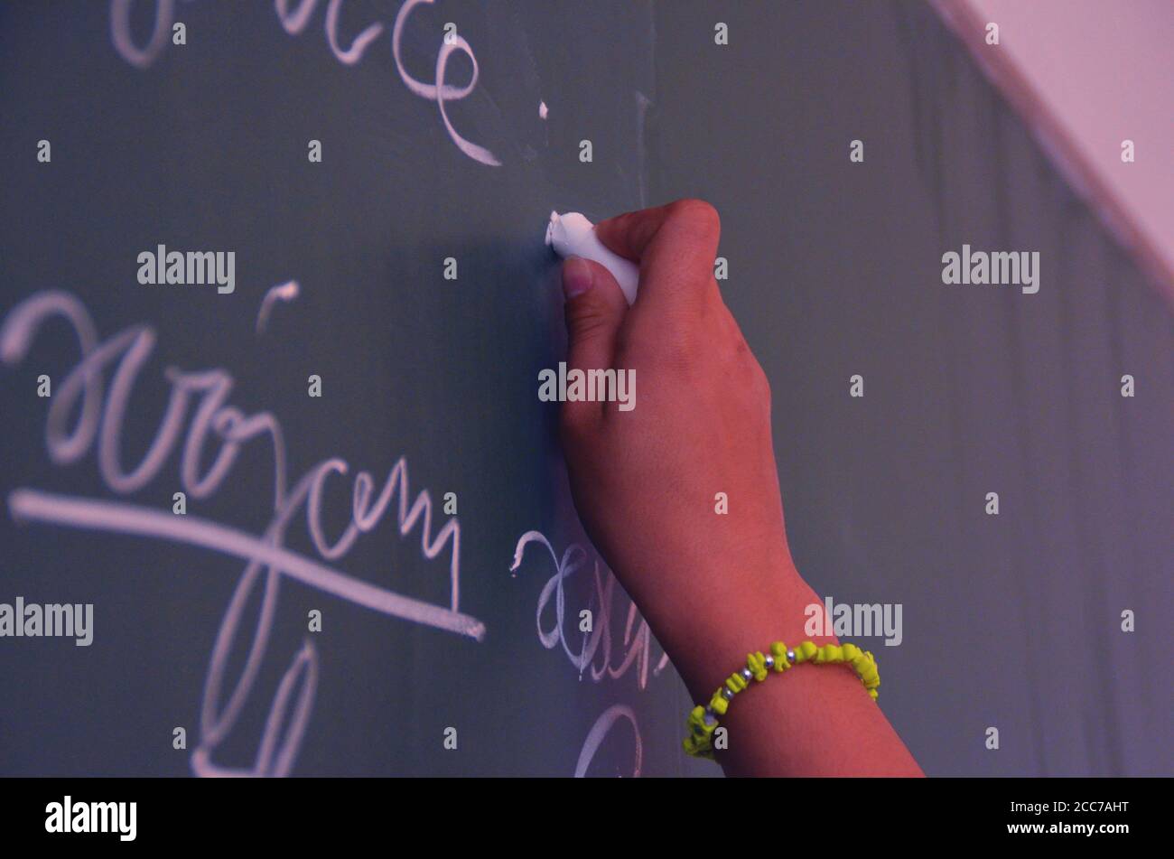 Student write some words at blackboard in the classroom; solve a task ...