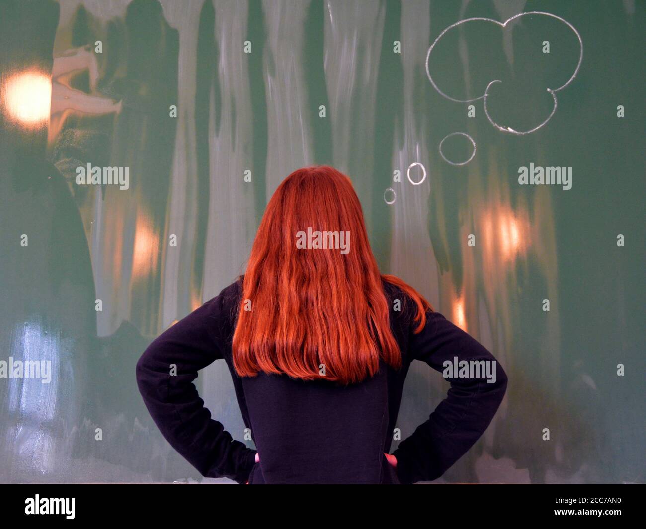 Redhead schoolgirl stands in front of the board and thinking...concept for add text Stock Photo