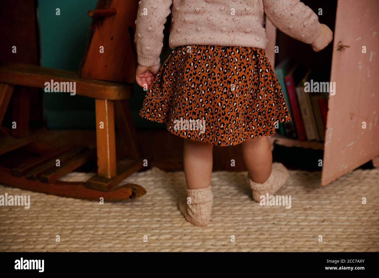 Toddler girl walking in room Stock Photo