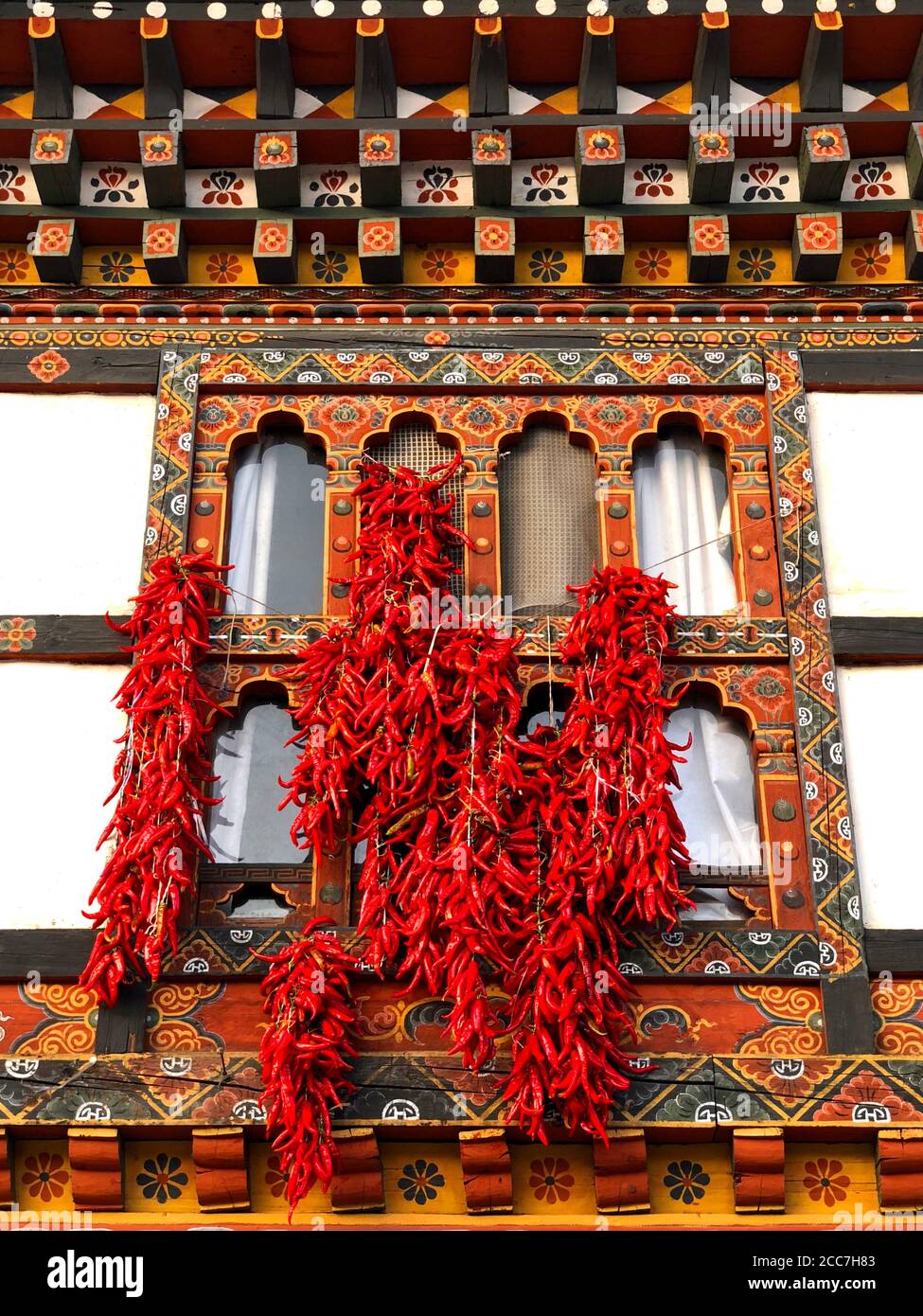 Red Chilli Peppers Hung to Dry Outside a Window in Bhutan Stock Photo
