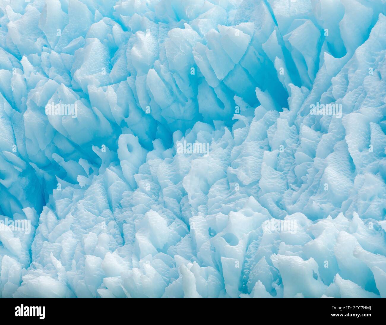 Close-up view of an iceberg, with a range of blue hues and interesting shapes and patterns, floating along the coast of Antarctica. Stock Photo