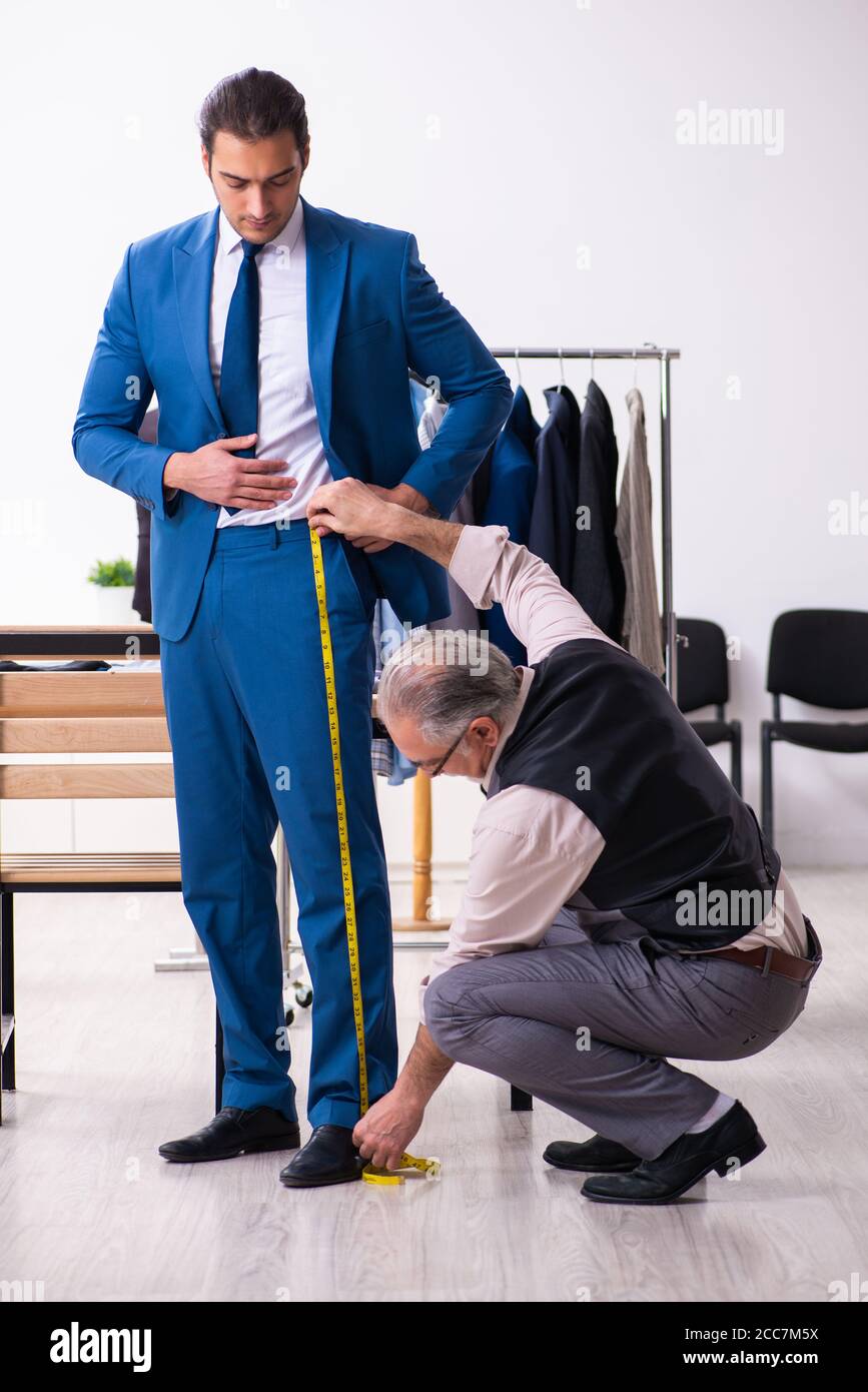 Young businessman visiting old tailor Stock Photo