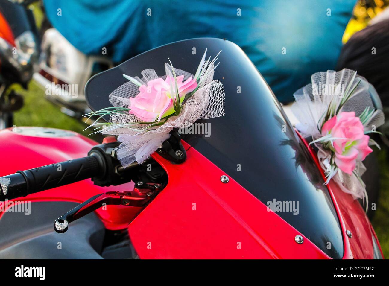 Red motorcycle with festive bows on the steering wheel. Moto decoration for wedding Stock Photo