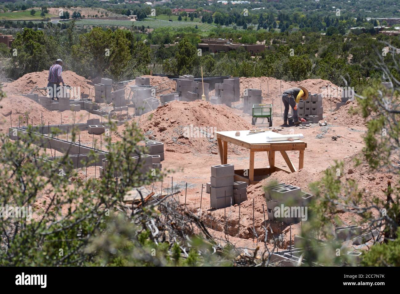 Construction workers lay a cinder block foundation for a new home being built overlooking Santa Fe, New Mexico USA. Stock Photo