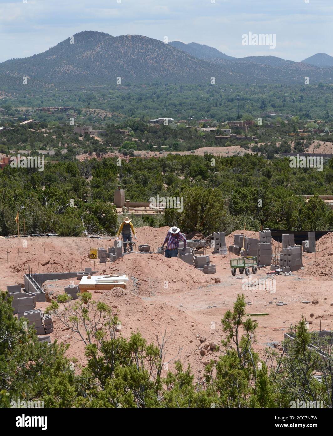 Construction workers lay a cinder block foundation for a new home being built overlooking Santa Fe, New Mexico USA. Stock Photo