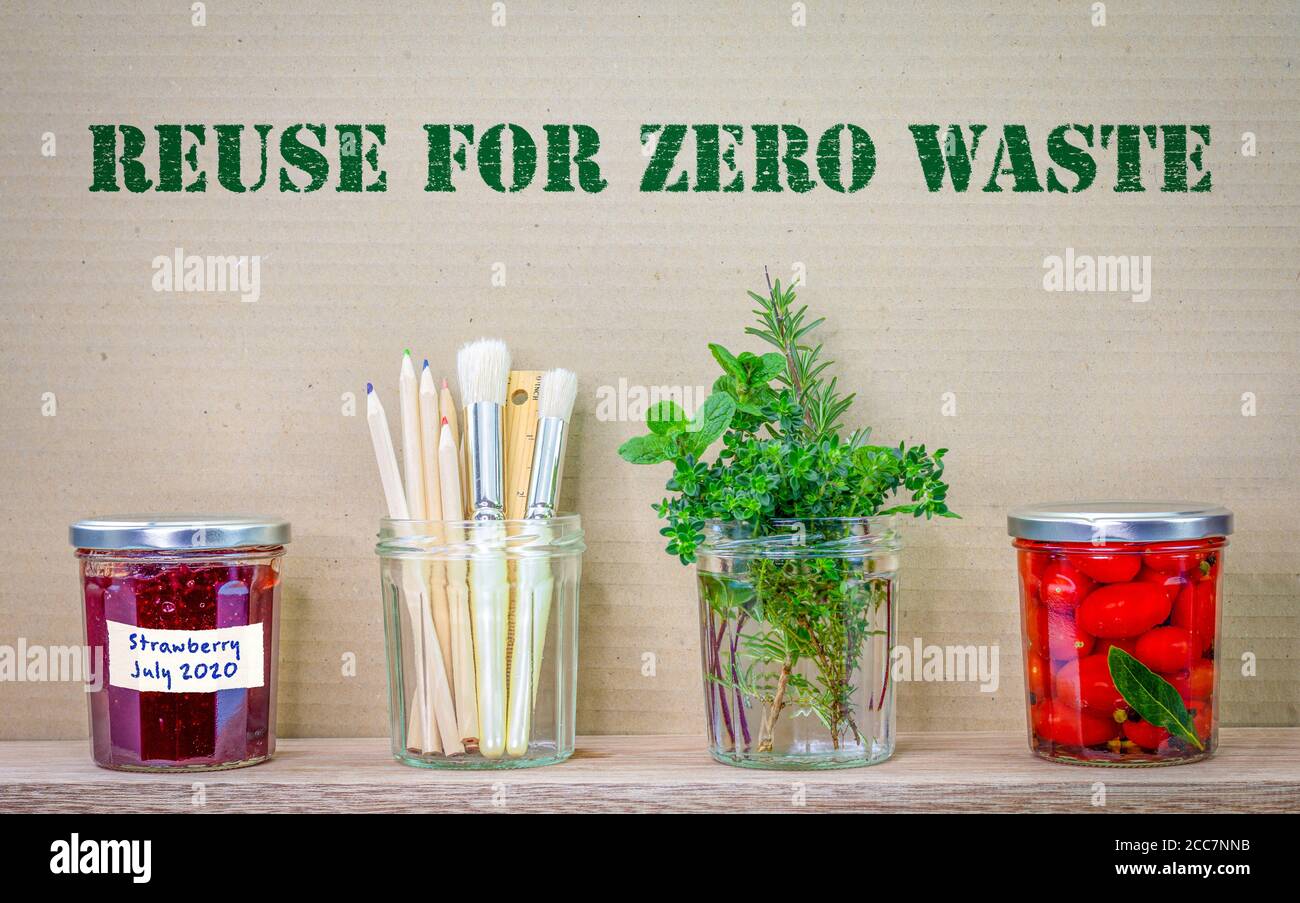 Jars reused with reuse for zero waste text on cardboard background, recycle and upcycle for sustainable living Stock Photo