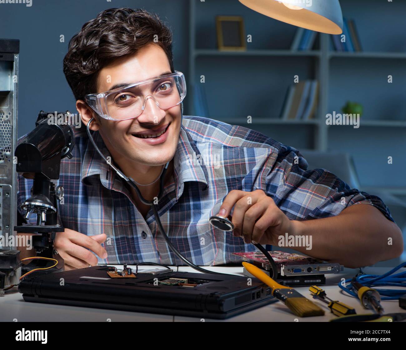 The computer repair concept with man inspecting with stethoscope Stock Photo Alamy