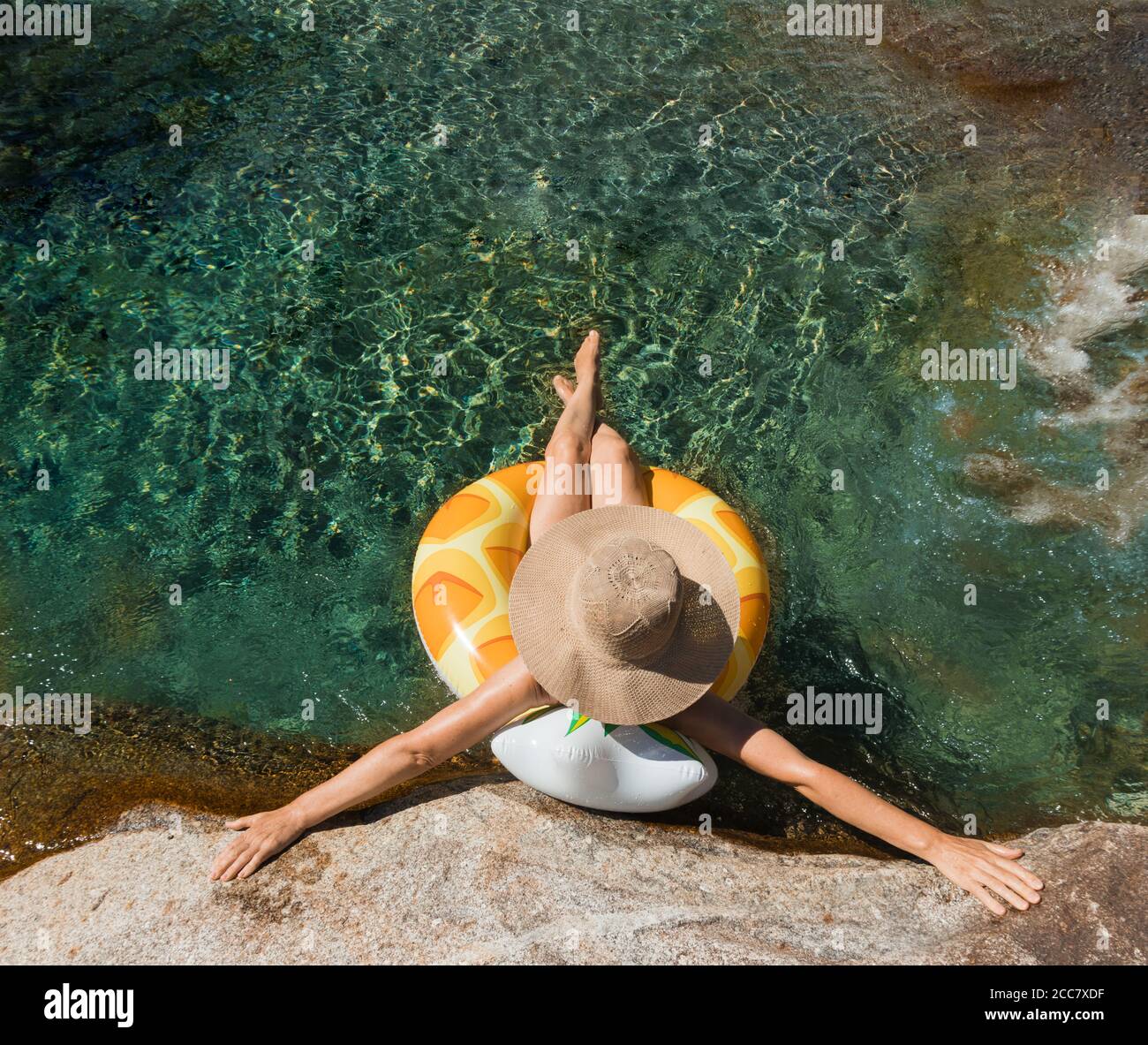 woman with pamela on a float on a mountain river, holidays in the mountain Stock Photo