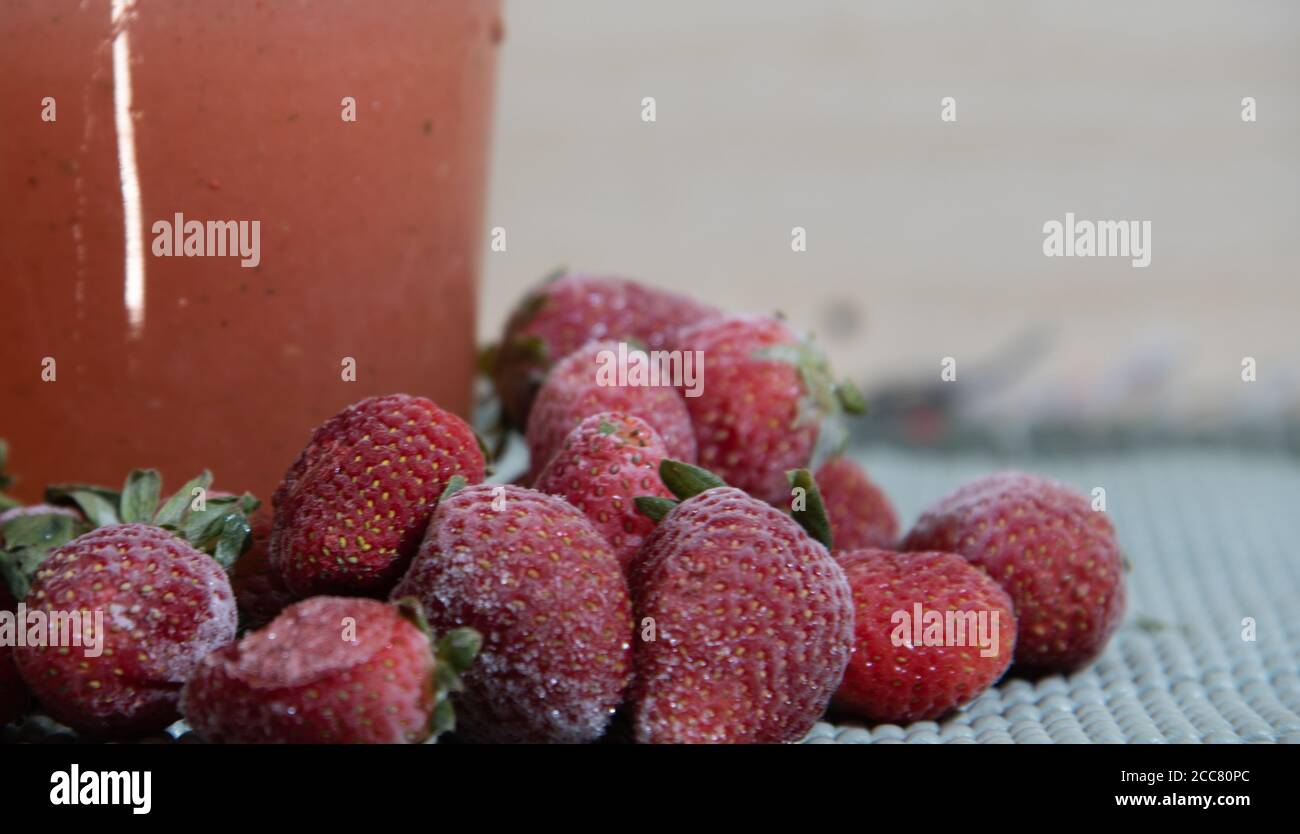 Frozen strawberries. Fresh red fruits. Glass of strawberry juice