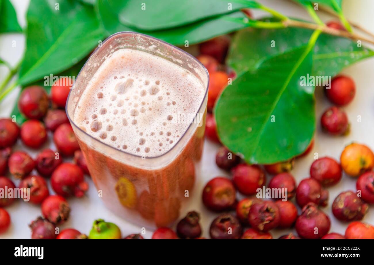 Fruits and red Maca juice. The araçá is a small, rounded fruit with seeds,  and the color of its pulp varies according to the species. They belong to t  Stock Photo -