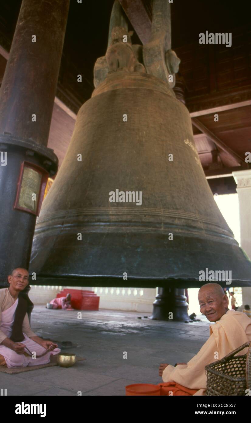 Burma / Myanmar: Buddhist nuns at the Mingun Bell in Sagaing Division, Burma. The Mingun Bell is a giant bell located in Mingun, on the western bank of the Irrawaddy River, Sagaing Region, Myanmar. It was the heaviest functioning bell in the world at several times in history. The weight of the bell is 90,718 kg or 199,999 pounds. The bell is uncracked and in good ringing condition. Casting of the bell started in 1808 and was finished by 1810. King Bodawpaya (r. 1782–1819) had this gigantic bell cast to go with his huge stupa, Mingun Pahtodawgyi. Stock Photo