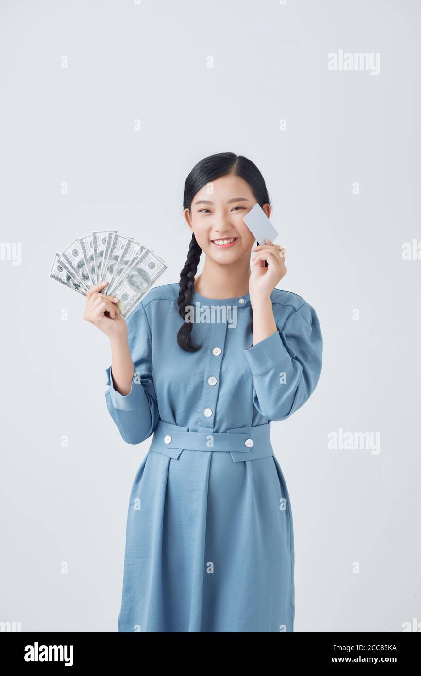 Portrait of a beautiful Asia woman holding credit card and money paper currency, sale concept Stock Photo