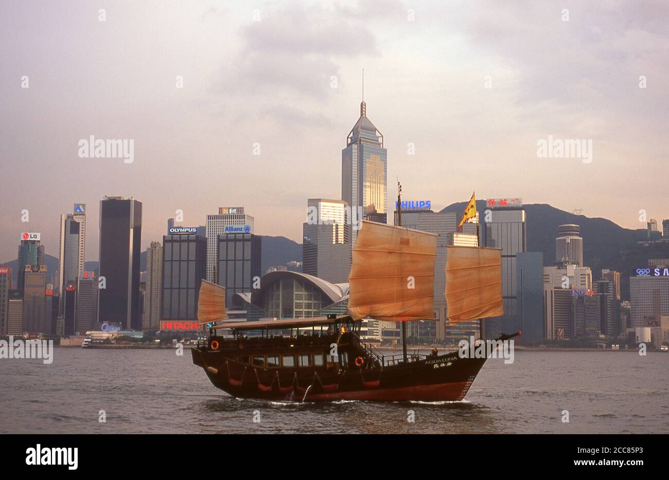 China: A junk crosses Victoria Harbour with Hong Kong's third highest building, Central Plaza rising in the background.  Originally a sparsely populated area of farming and fishing villages, Hong Kong has become one of the world's most significant financial centres and commercial ports. It is the world's tenth-largest exporter and ninth-largest importer.  Hong Kong became a colony of the British Empire after the Qing Empire ceded Hong Kong Island at the end of the First Opium War in 1842. Stock Photo