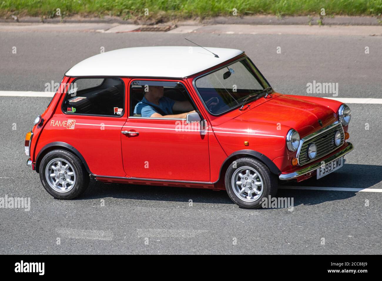 1989 80s red white old type Austin Mini Racing Flame; Vehicular traffic moving vehicles, 80s cars driving vehicle on UK roads, motors, motoring on the M6 motorway highway network. Stock Photo