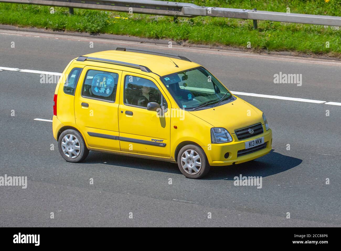 2004 yellow Suzuki Wagon R+ GL Auto; Vehicular traffic moving vehicles, cars driving vehicle on UK roads, motors, motoring on the M6 motorway highway network. Stock Photo