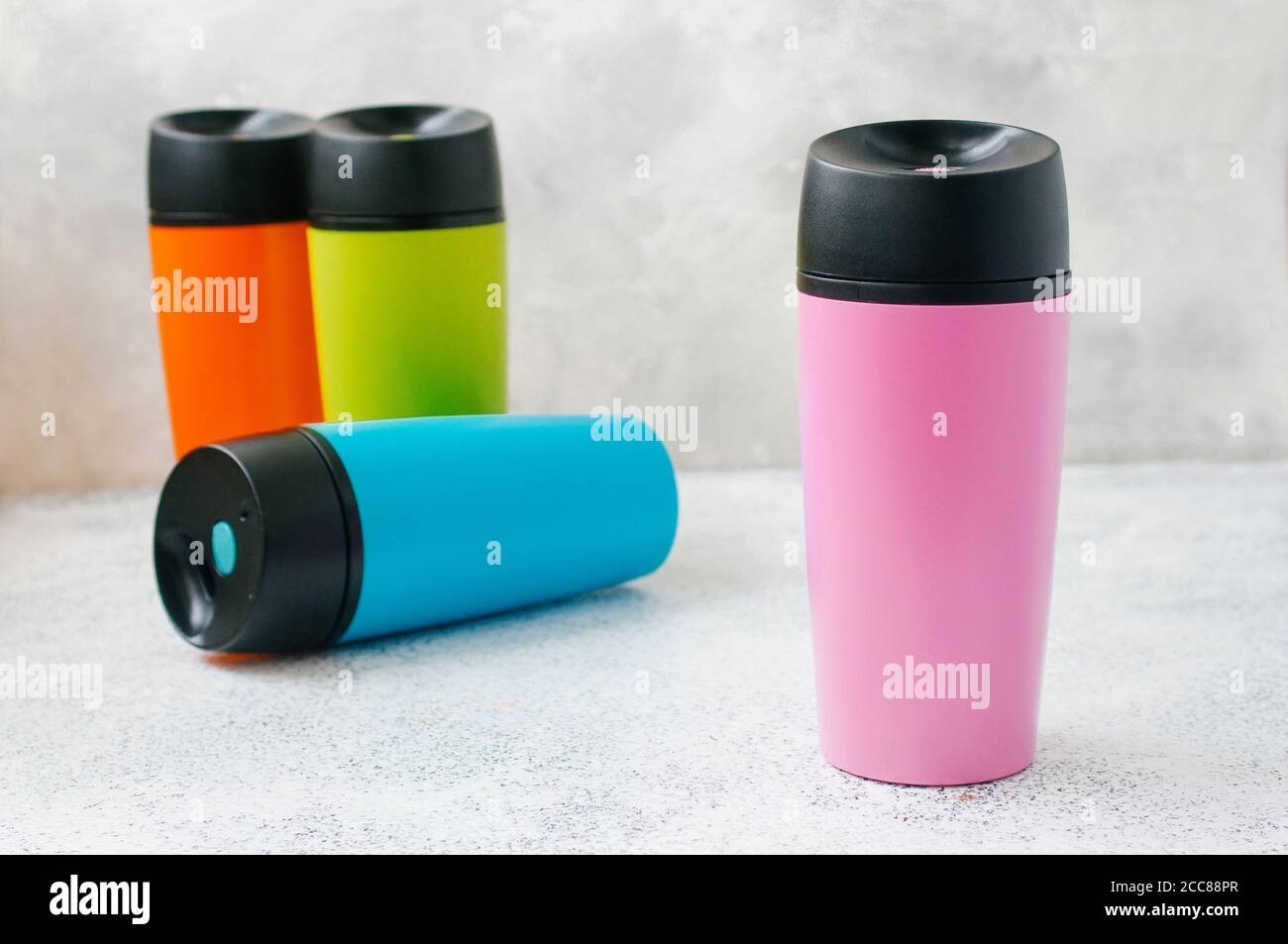 Four thermos mugs on grey background with copy space Stock Photo