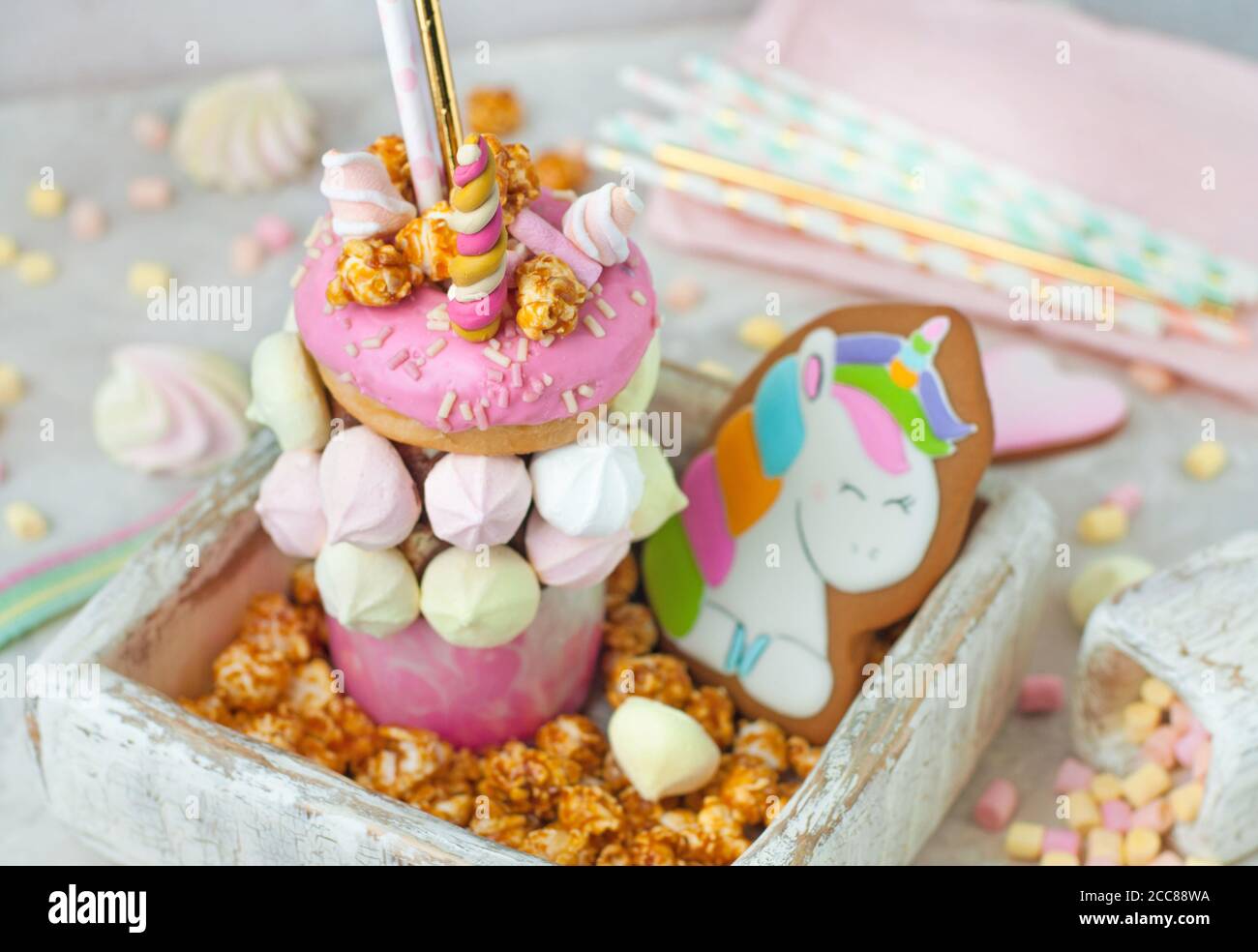 Freak shake decorated as unicorn in the wooden box filled with popcorn Stock Photo