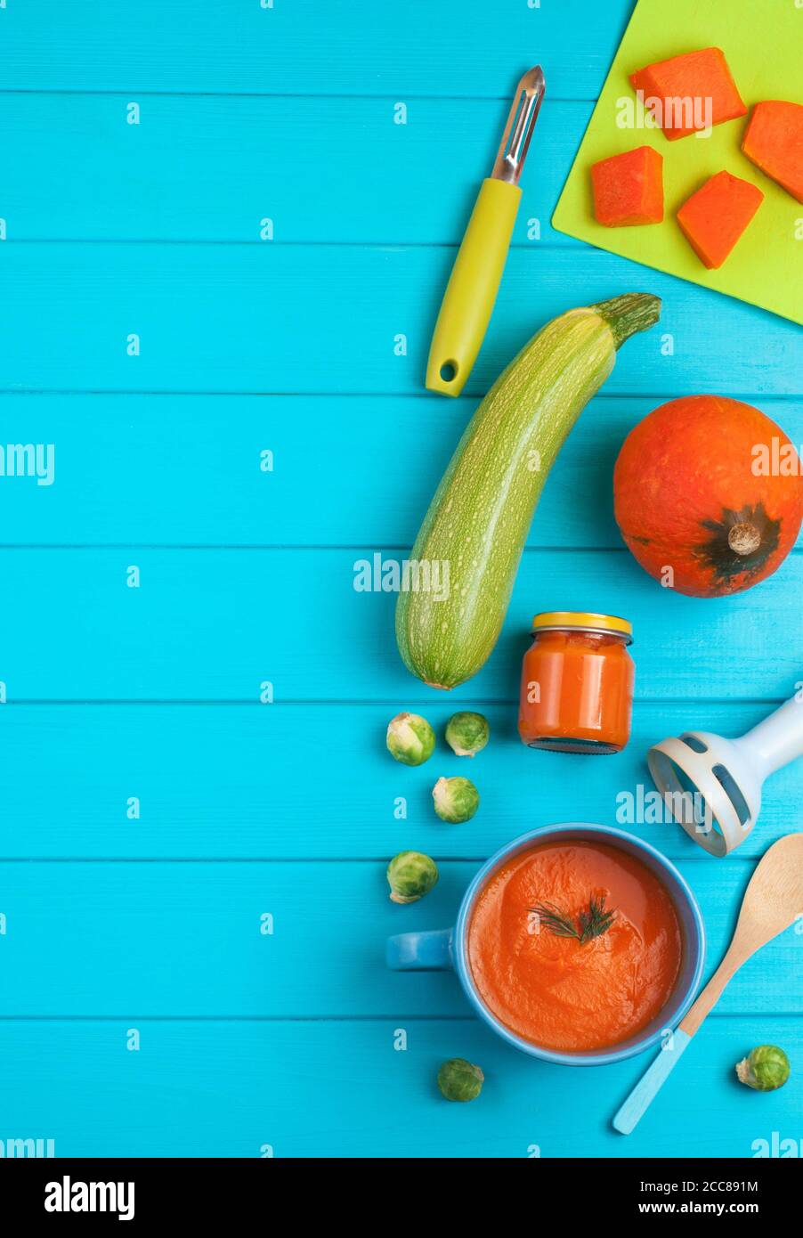 Fresh natural pumpkin puree for baby on blue background Stock Photo