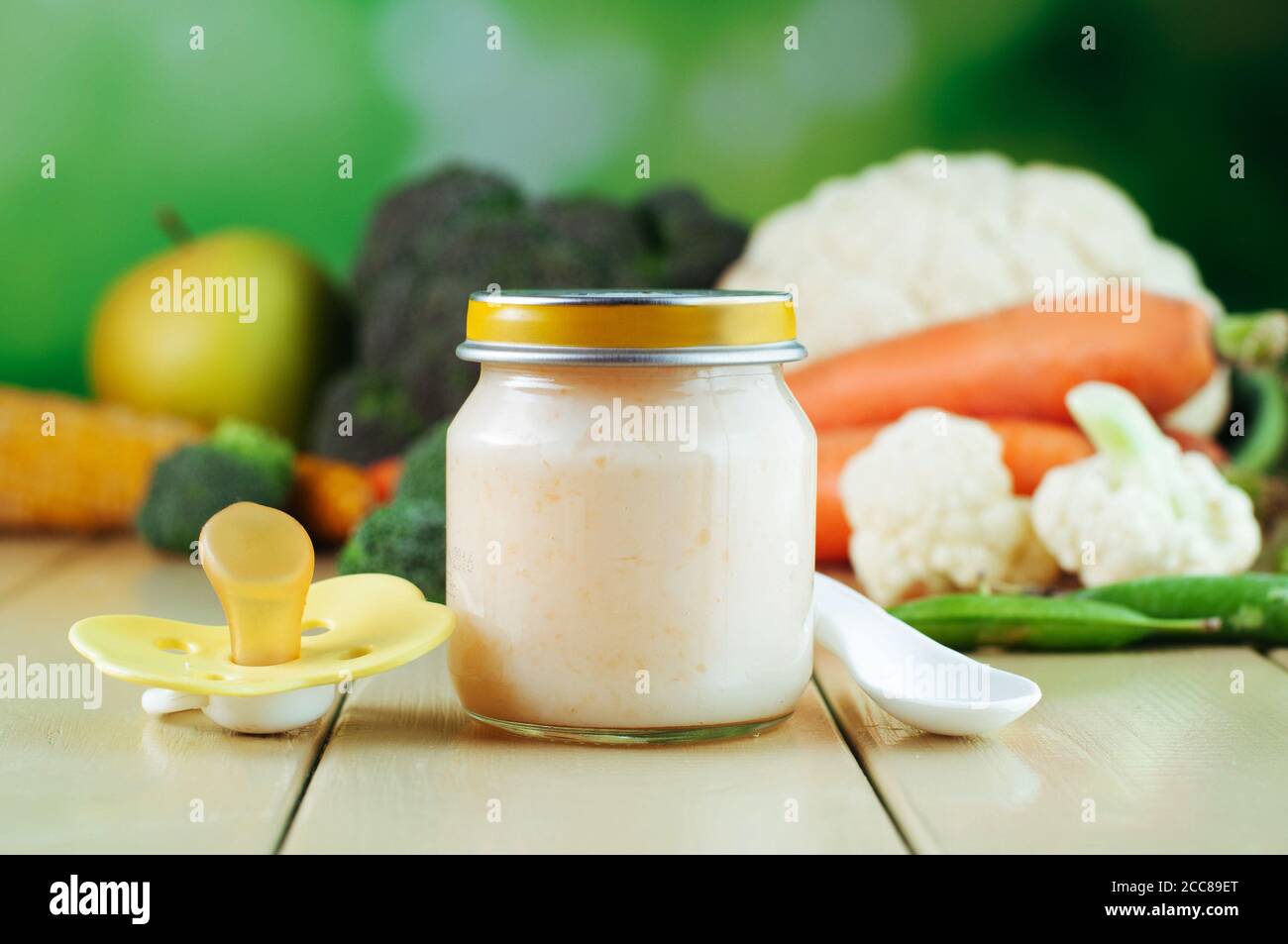 Jar with vegetable puree and pacifier on the light wooden background Stock Photo