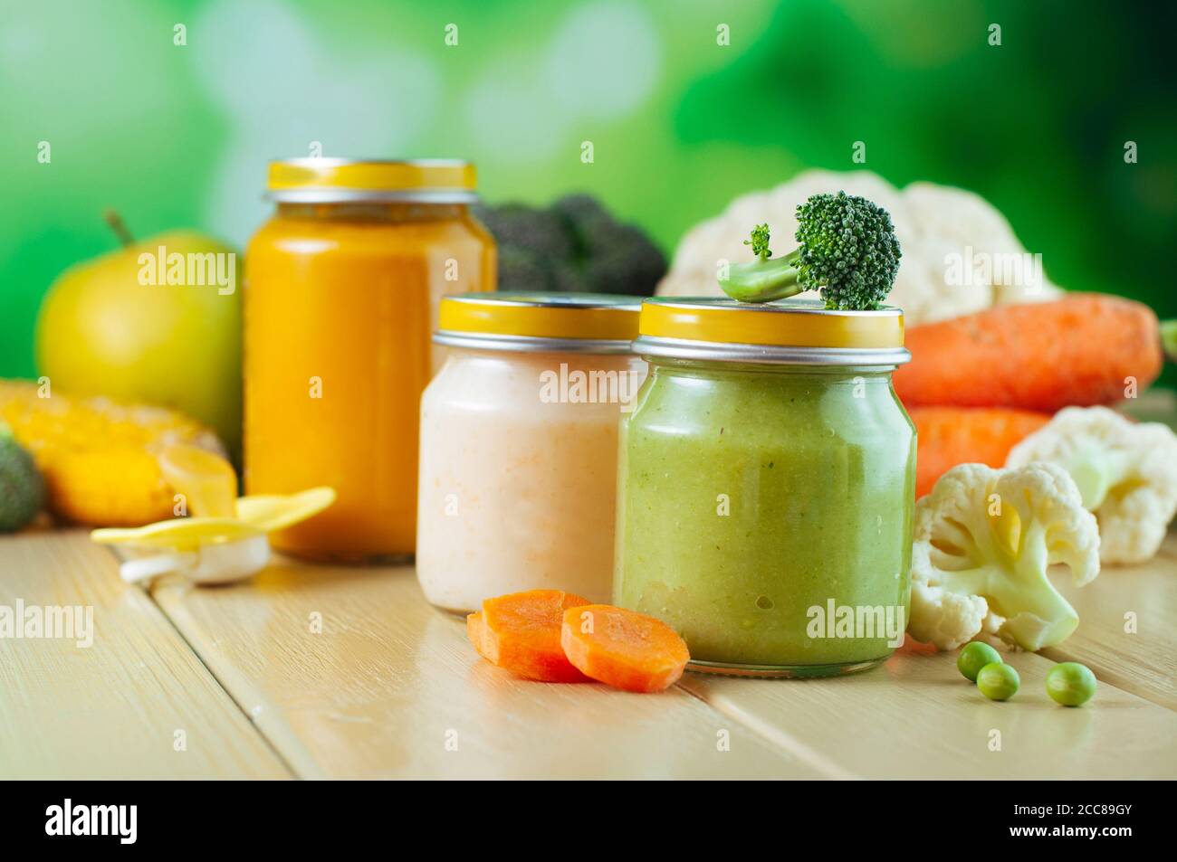 Jars with vegetable puree on the light wooden background Stock Photo
