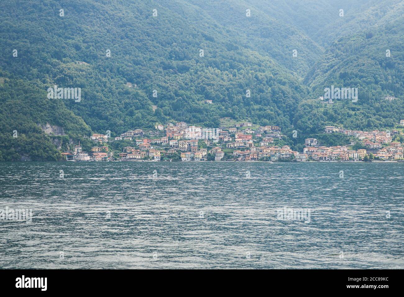 Panorama at Lake Como. Lezzeno Town on Background. Hills Covered Green Forest. Italy. Stock Photo