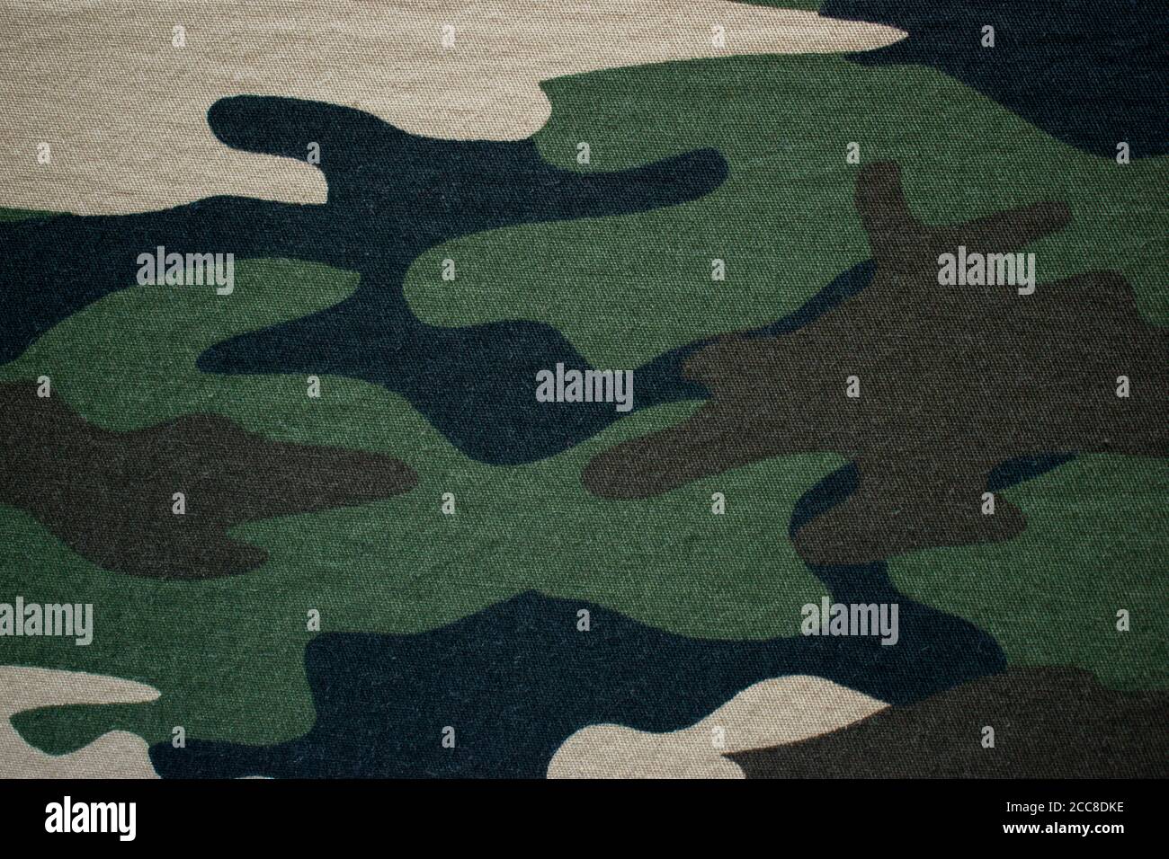 Green military camouflage fabric, cloth background with beige, brown and black spots Stock Photo