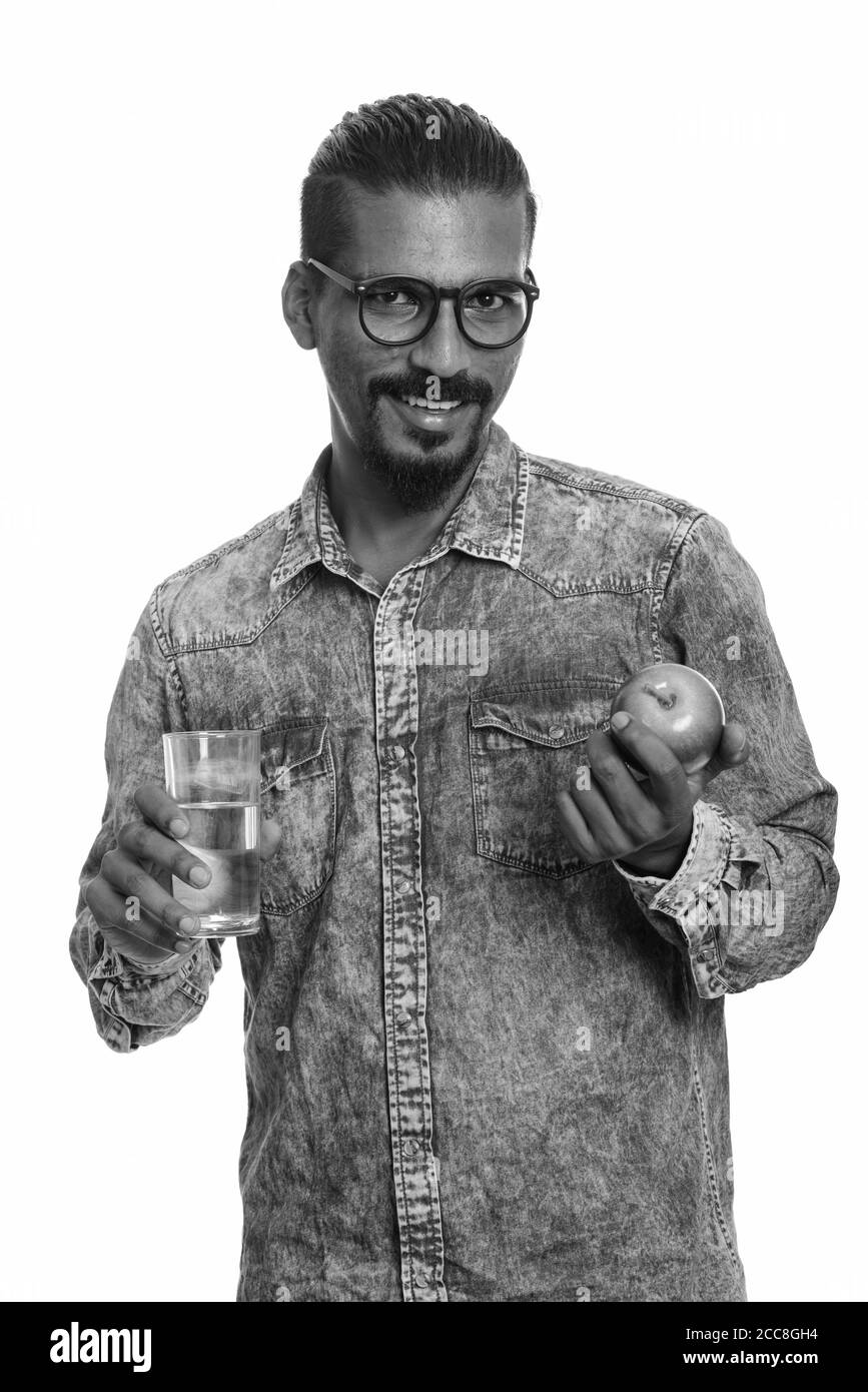 Young happy Indian man holding red apple and glass of water Stock Photo ...