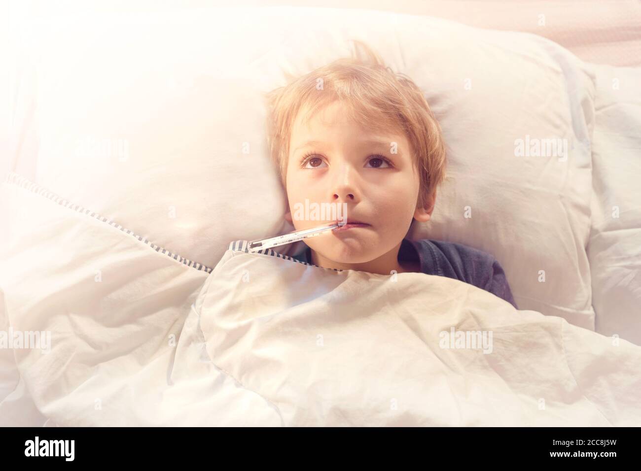 child sick in bed with fever and thermometer Stock Photo Alamy