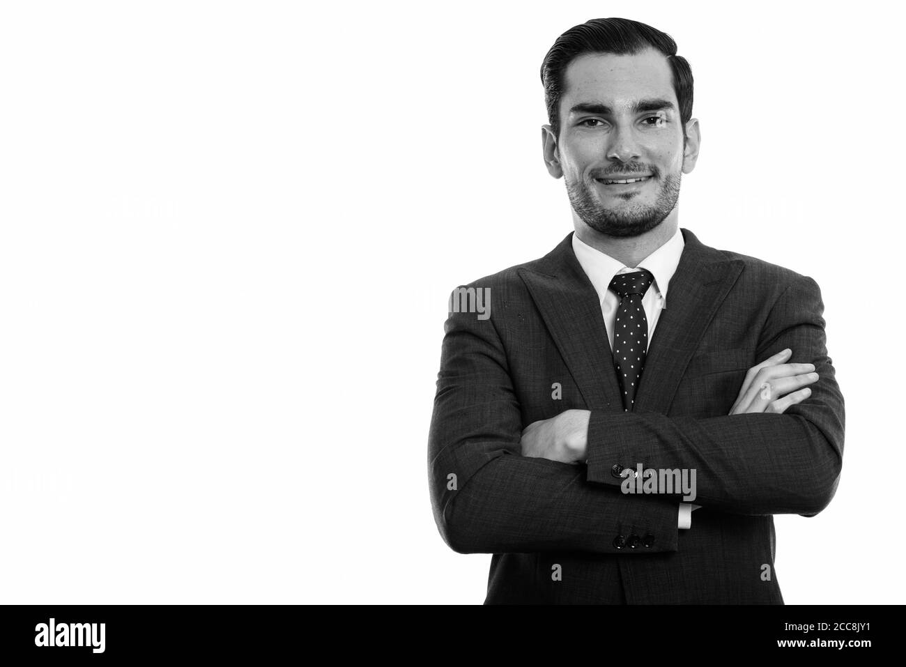 Studio shot of happy young handsome businessman smiling with arms ...