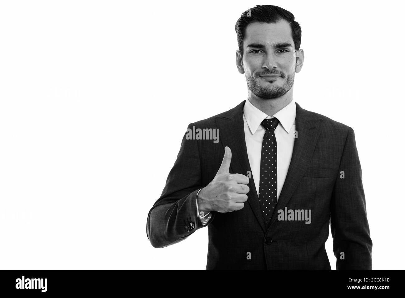 Studio shot of young handsome businessman giving thumb up Stock Photo