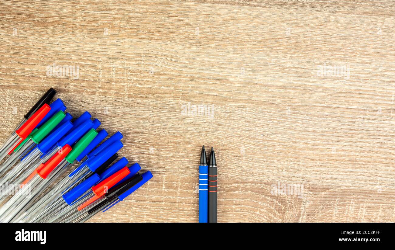 Pile of a lot multi colored plastic ballpoint pens on wooden table ...