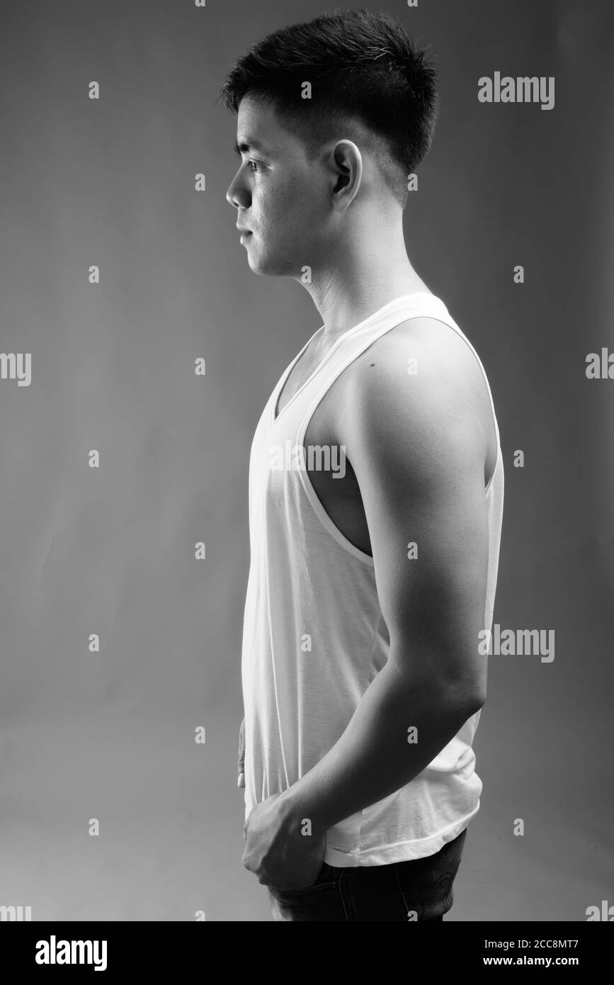 Young handsome Asian man wearing tank top against gray background Stock Photo