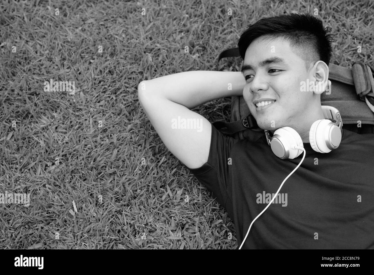 Young handsome Asian man relaxing at the park Stock Photo