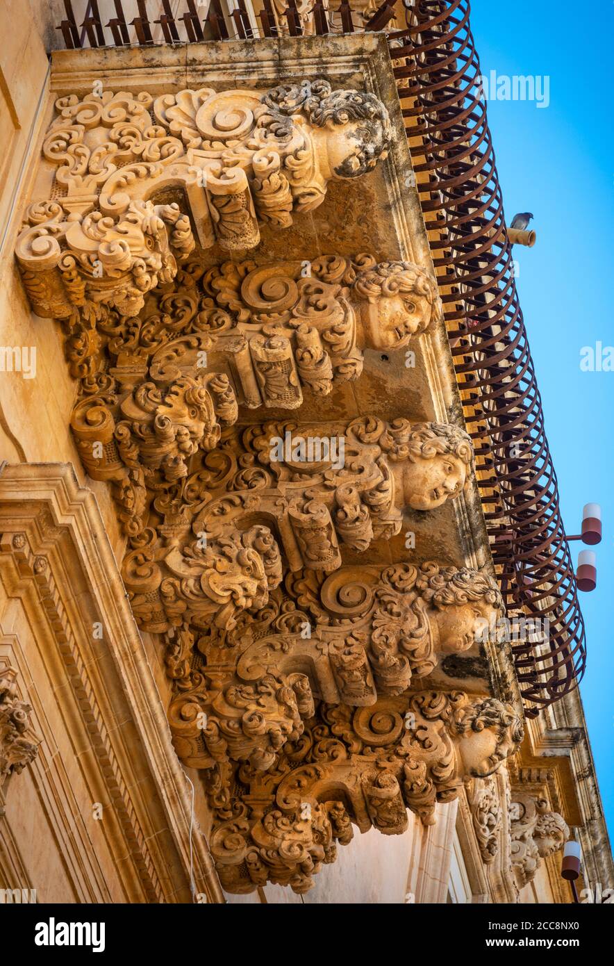 Ornately carved stone balcony on the Baroque Palazzo Villadorata in Noto, South Eastern Sicily, Stock Photo