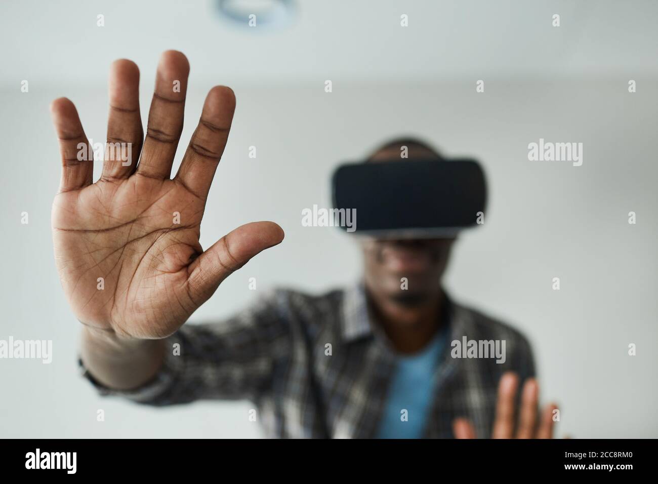 African man in glasses gesturing while playing in virtual reality game Stock Photo