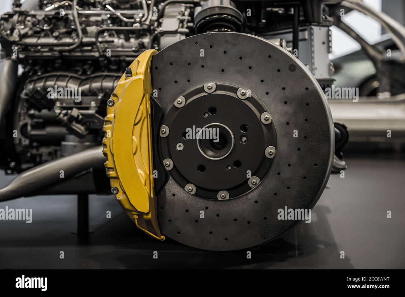 Automobile braking system. Ceramic carbon disk with perforation, ventilation and yellow calipers. Stock Photo