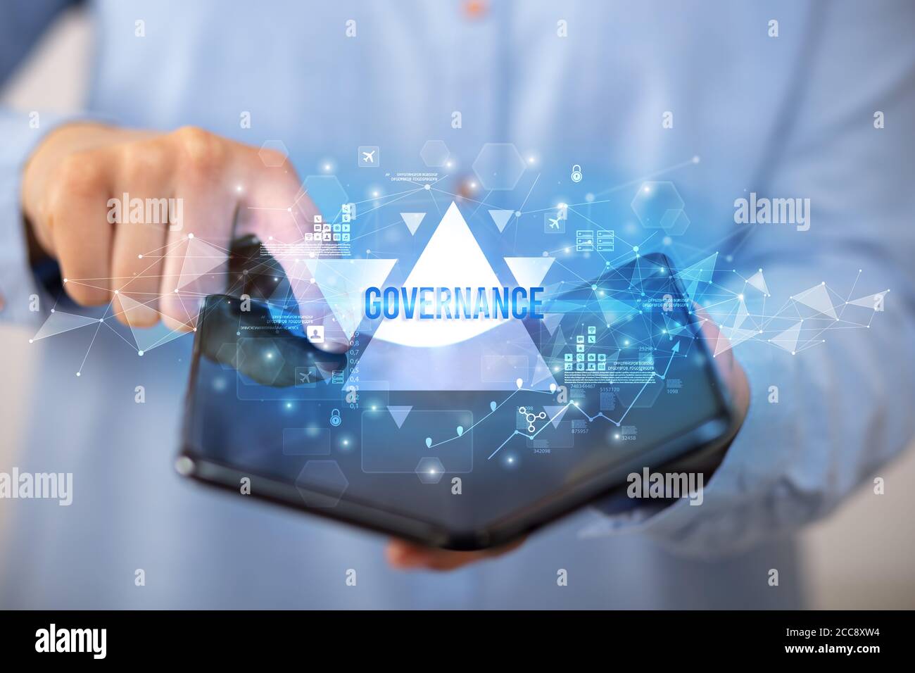 Businessman holding a foldable smartphone with GOVERNANCE inscription, business concept Stock Photo