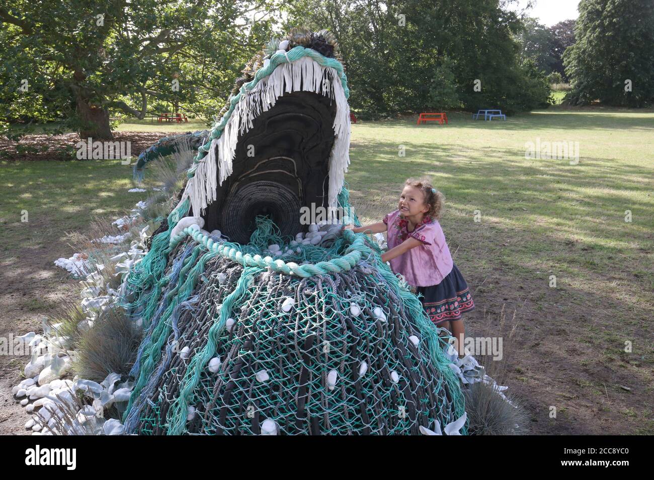 Five year old Sylvie Fodio Todd from Lewes looking at the botanical sculpture of a humpback whale emerging from the Orangery Lawn as it goes on on display until September 18 as part of the Travel the World at Kew festival at the Royal Botanic Gardens in London. Stock Photo