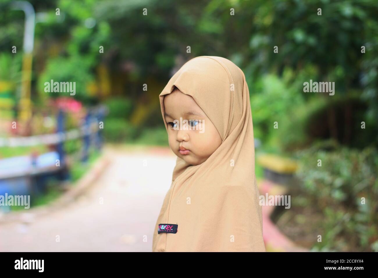 A cute beautiful muslim Indonesian baby girl in the park Stock Photo