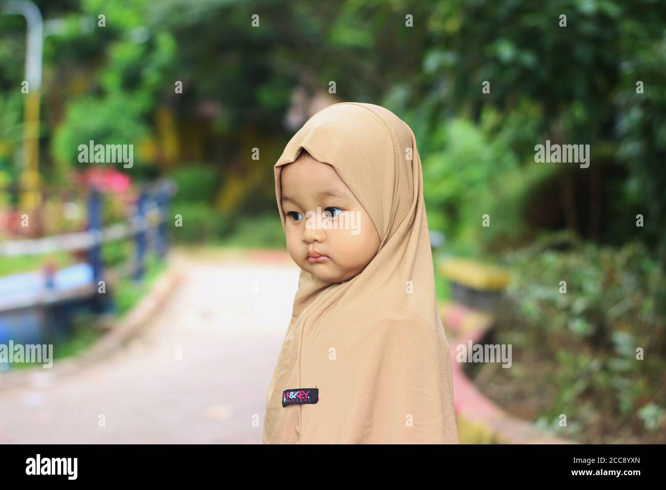 A cute beautiful muslim Indonesian baby girl in the park Stock Photo