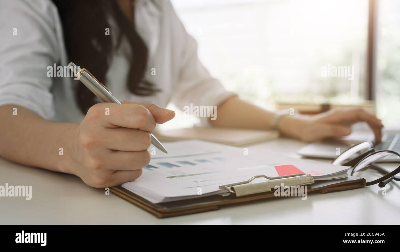 Business woman investment consultant analyzing company annual financial report balance sheet statement working with documents graphs. Concept picture Stock Photo