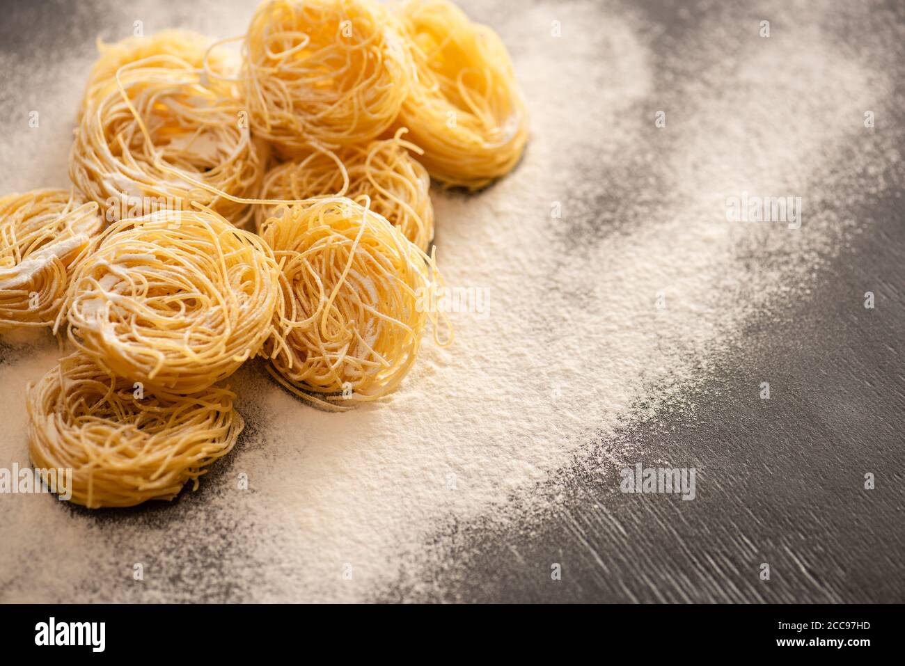raw Italian Capellini with flour on black background Stock Photo Alamy
