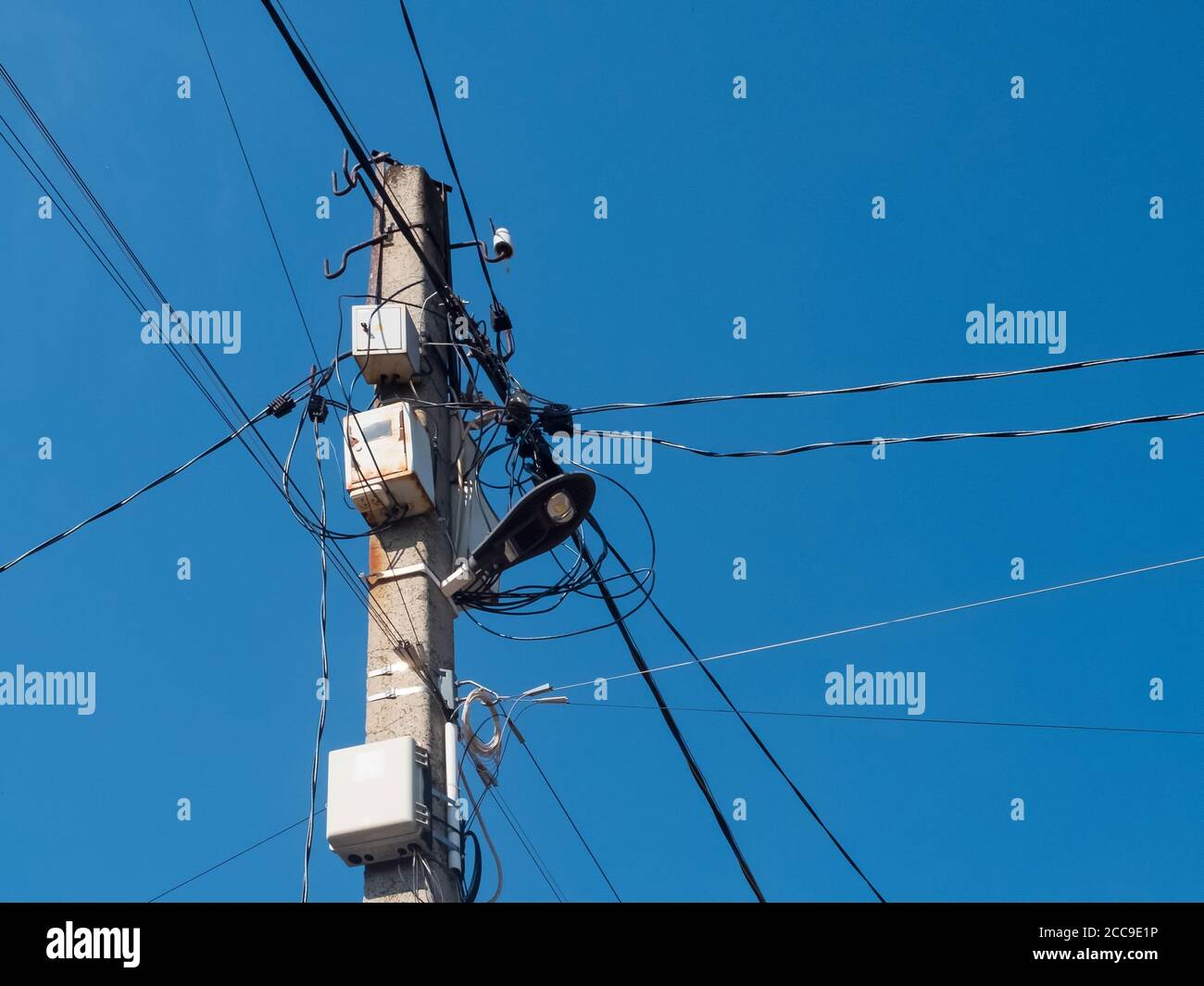 Concrete pole with lantern and lots of electric wires Stock Photo - Alamy