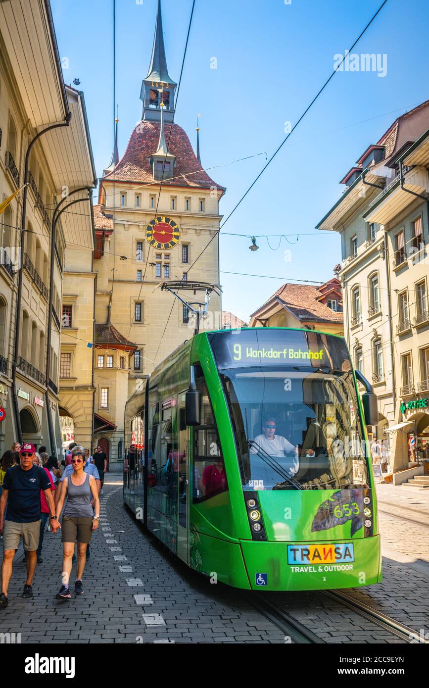 Bern Switzerland , 27 June 2020 : Vertical view of green tram and Käfigturm or prison tower in Marktgasse street in Bern old town Switzerland Stock Photo