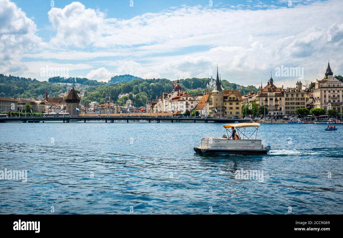 Lucerne Switzerland , 28 June 2020 : Tourists on a license free boat to rent on Lucerne lake and city with landmarks such as chapel bridge in backgrou Stock Photo