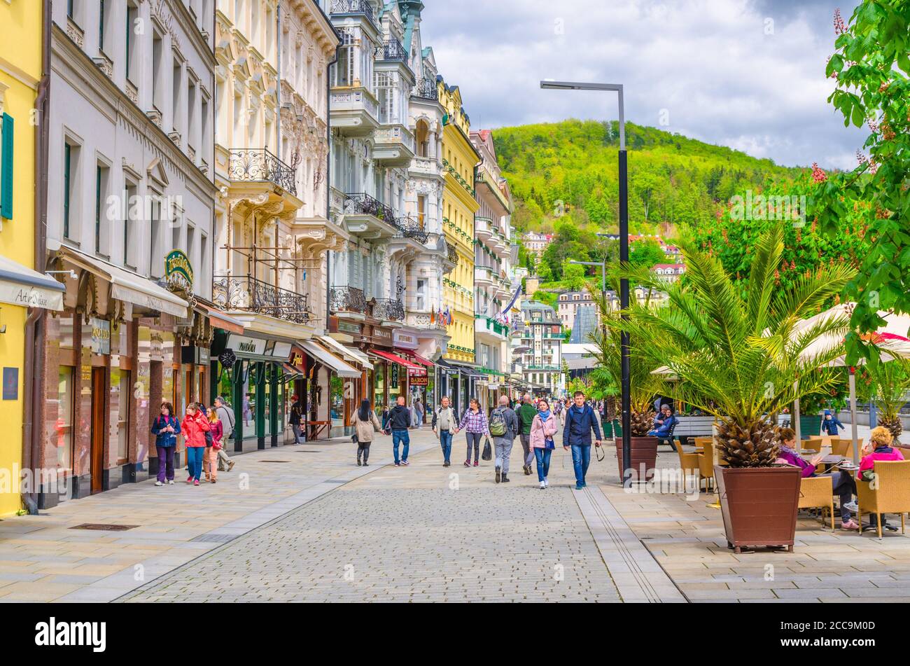 Karlovy Vary, Czech Republic, May 9, 2019: people are walking down street and Tepla river embankment in Carlsbad historical city centre with colorful traditional beautiful buildings, West Bohemia Stock Photo