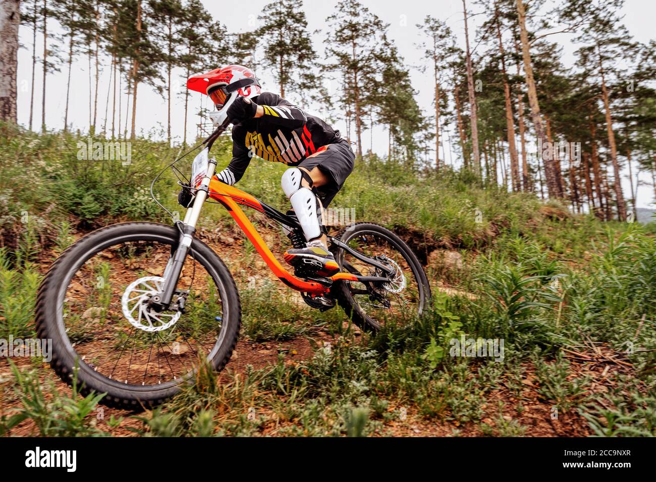 downhill mountain biker on forest trail. competition DH Stock Photo