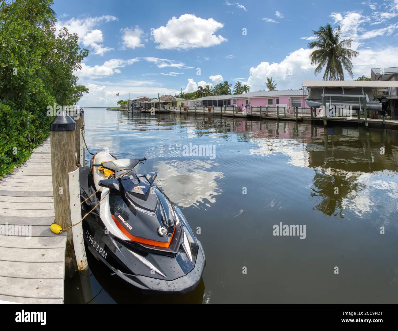 Jet Ski at dock in canal with colorful residental houses in Matlacha on