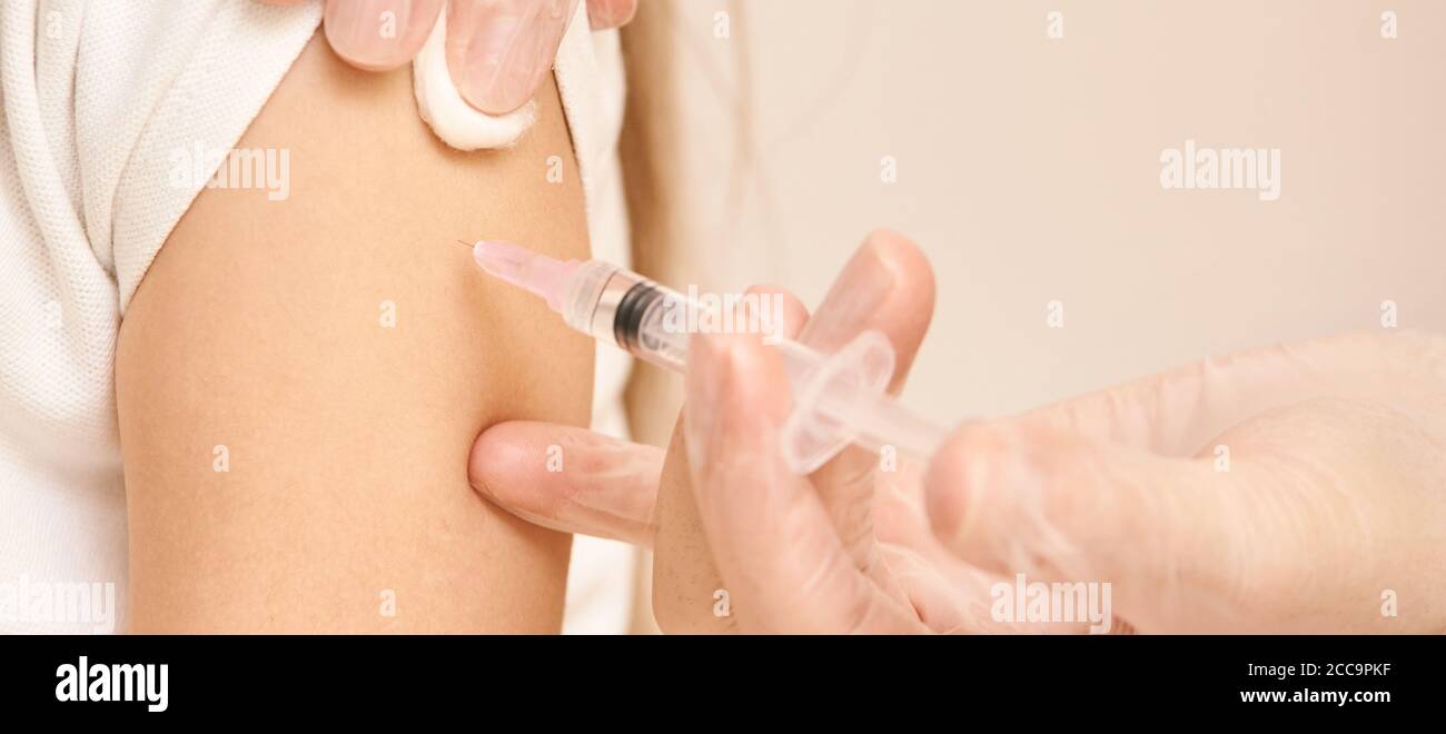 Doctor do injection to young girl. Kid immunization Stock Photo - Alamy
