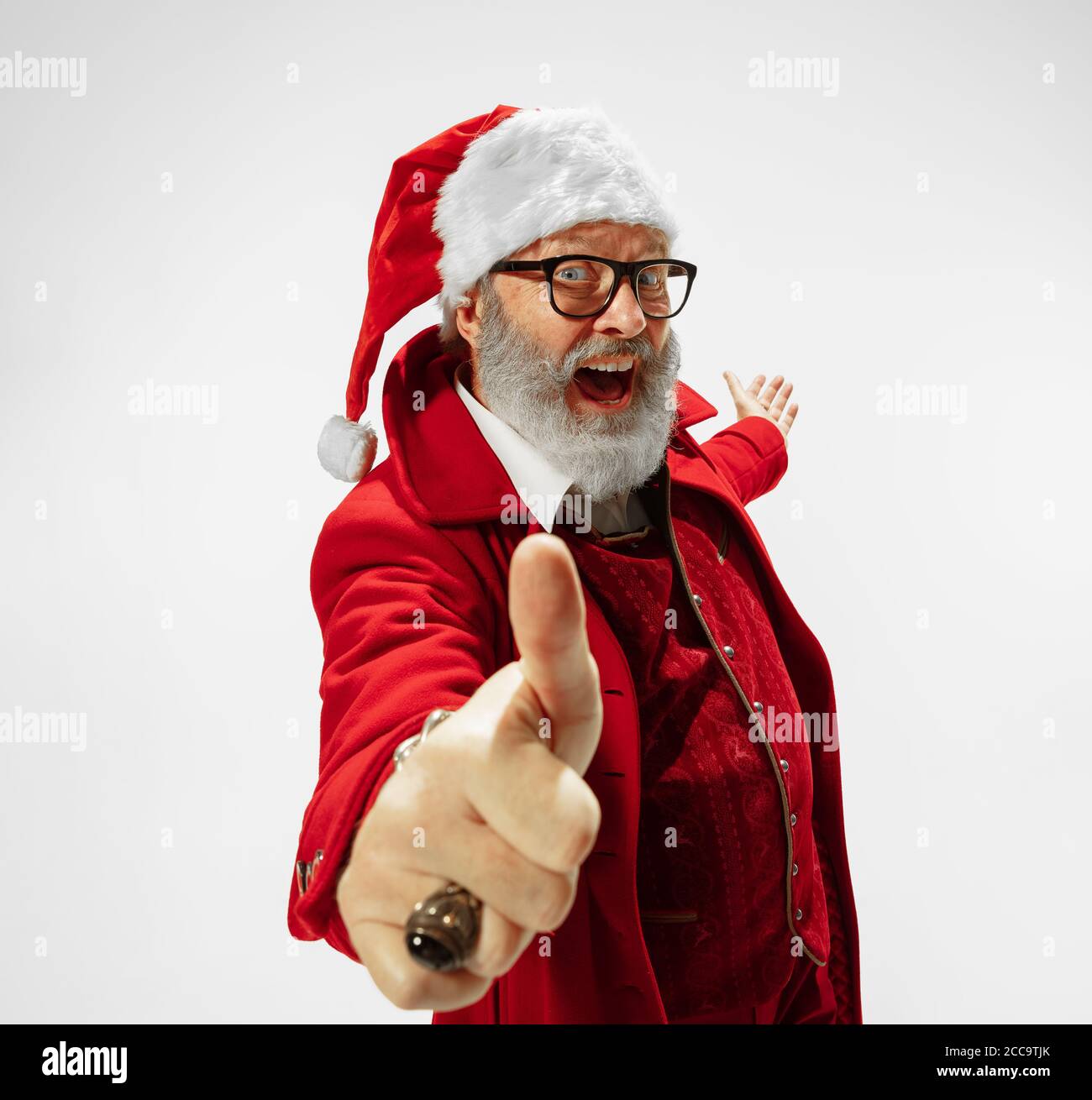 Thumbs up, cool. Modern stylish Santa Claus in red fashionable suit ...